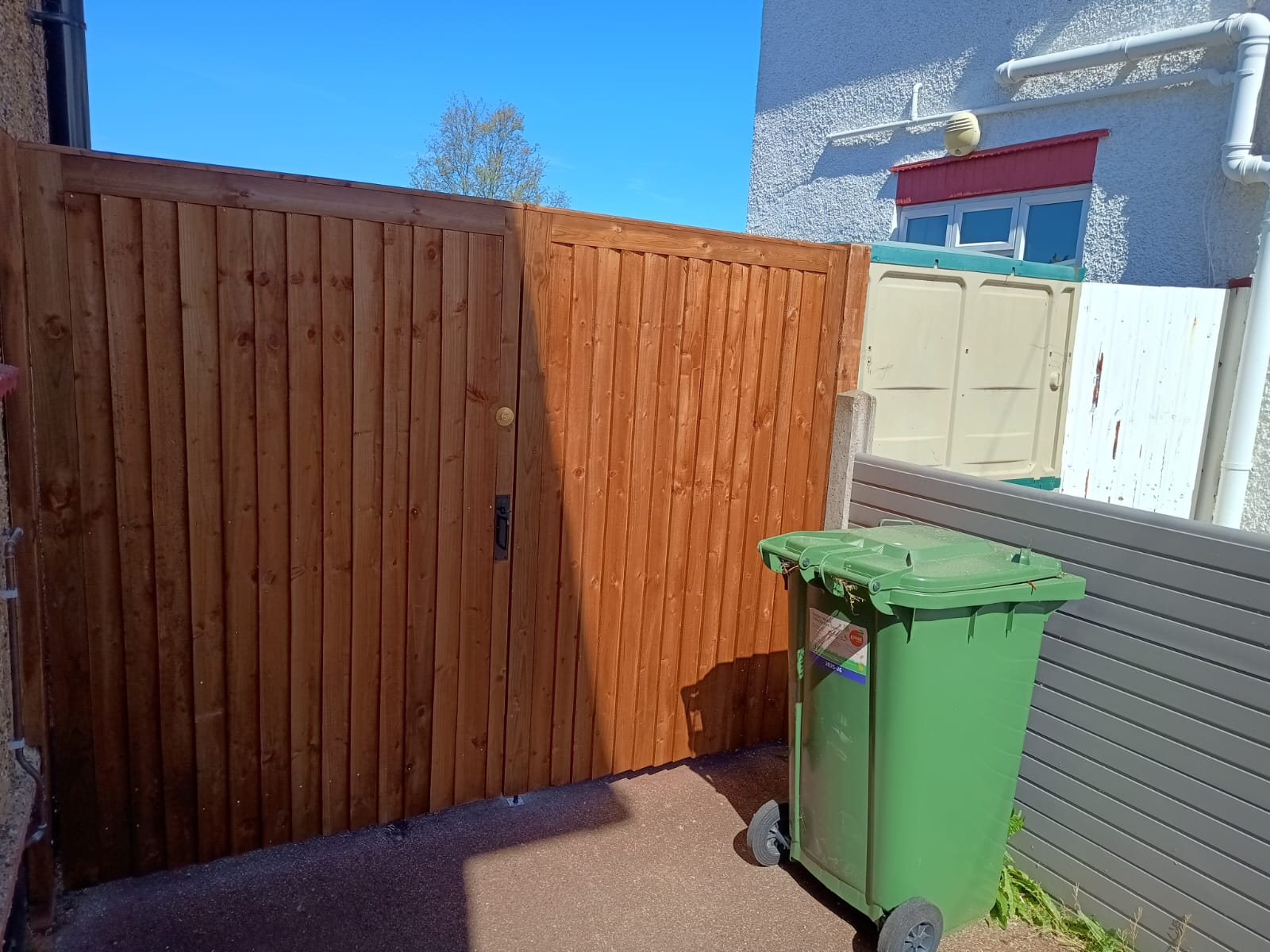 New closeboard side gate and matching panel after replacement